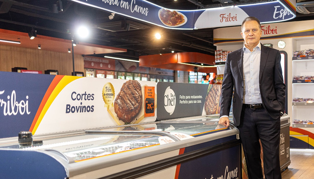 Executivo em loja Friboi ao lado de freezer de carnes