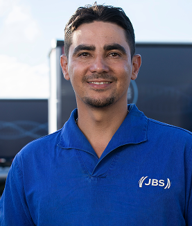 Man smiling in a blue JBS polo shirt.