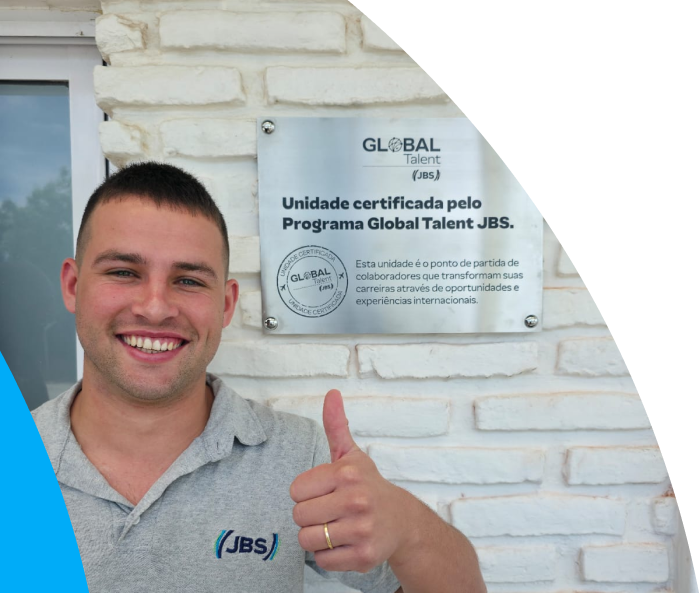 JBS employee smiling in front of Global Talent plaque
