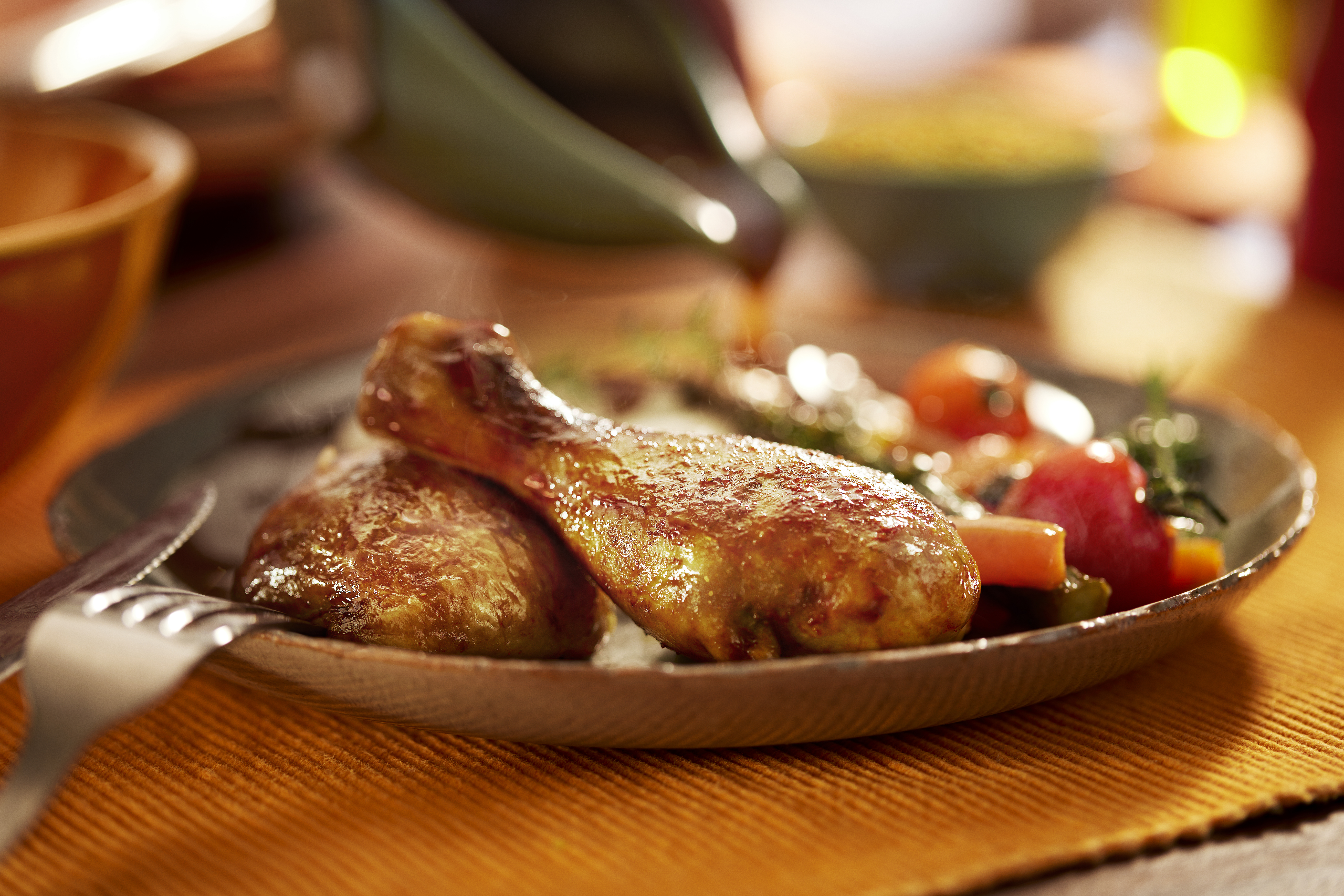 coxa e sobrecoxa de frango preparadas sobre tigela ao lado de legumes